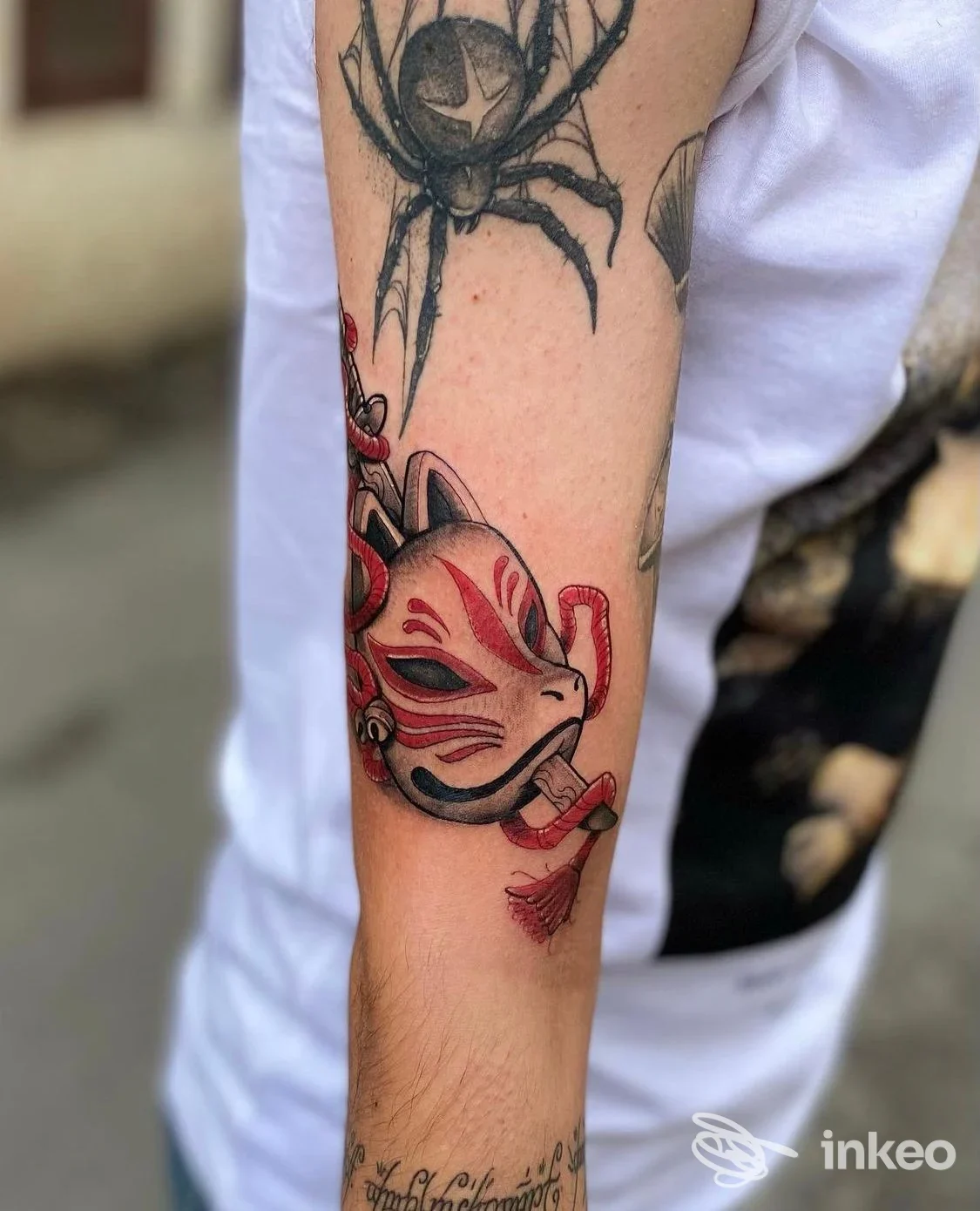 Dettaglio dell'avambraccio con tatuaggio a maschera in rosso e nero; foto fornita da Bloody Velvet Tattoo Shop, Marsicovetere.