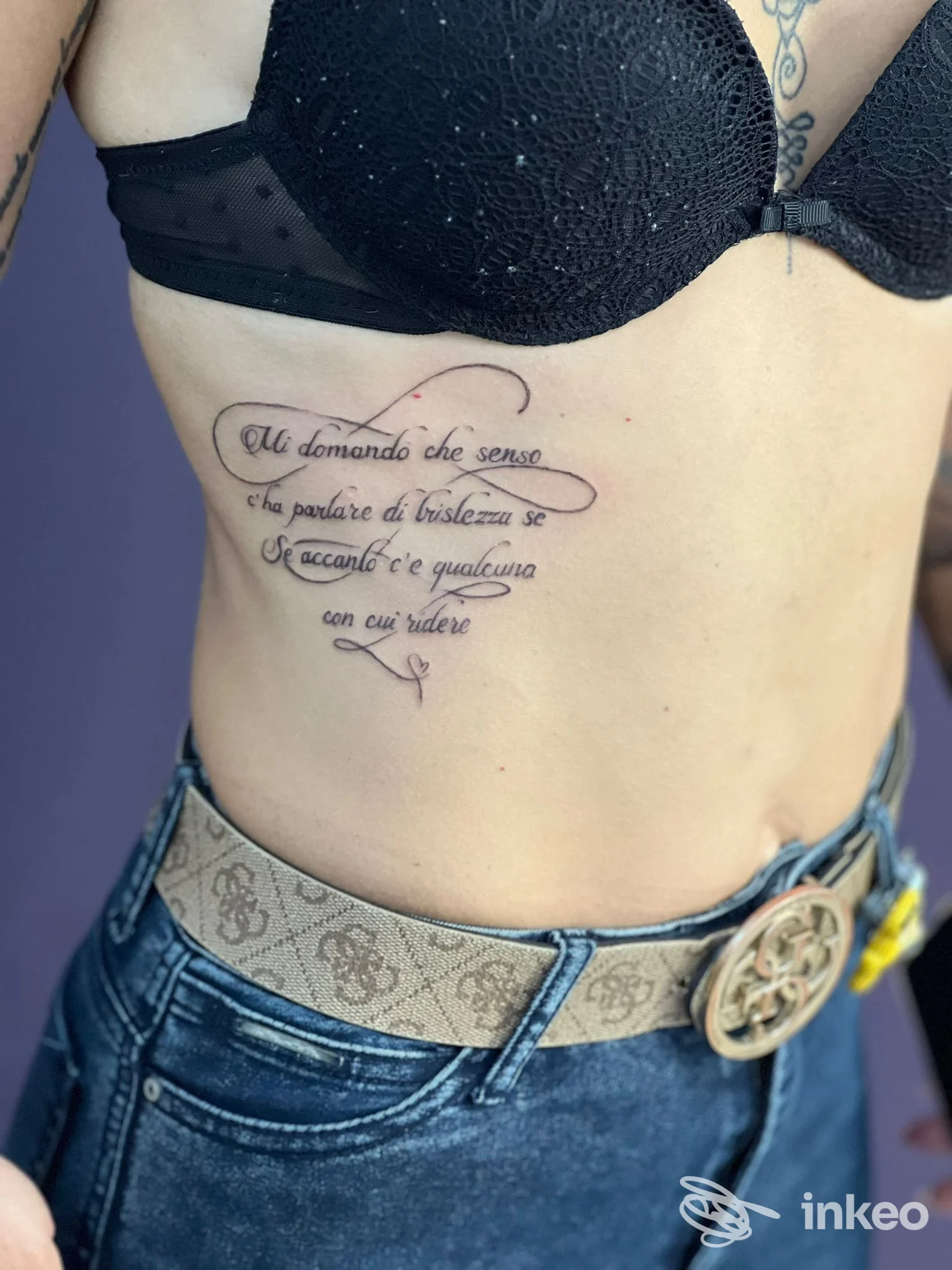 Tatuaggio calligrafico a righe sul fianco sotto il seno, foto inviata da Minerva Studio Tattoo a Matera.