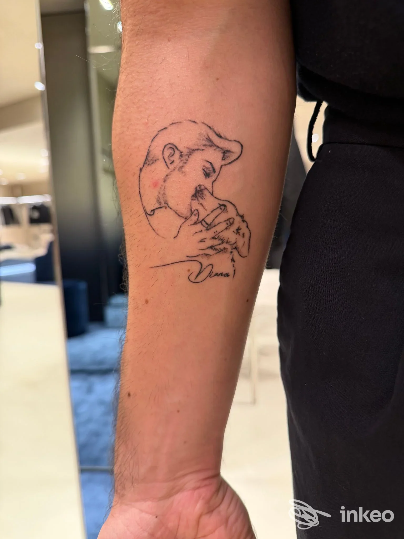 Tatuaggio linework su avambraccio raffigurante un volto stilizzato che bacia una mano, Minerva Studio Tattoo, Matera.