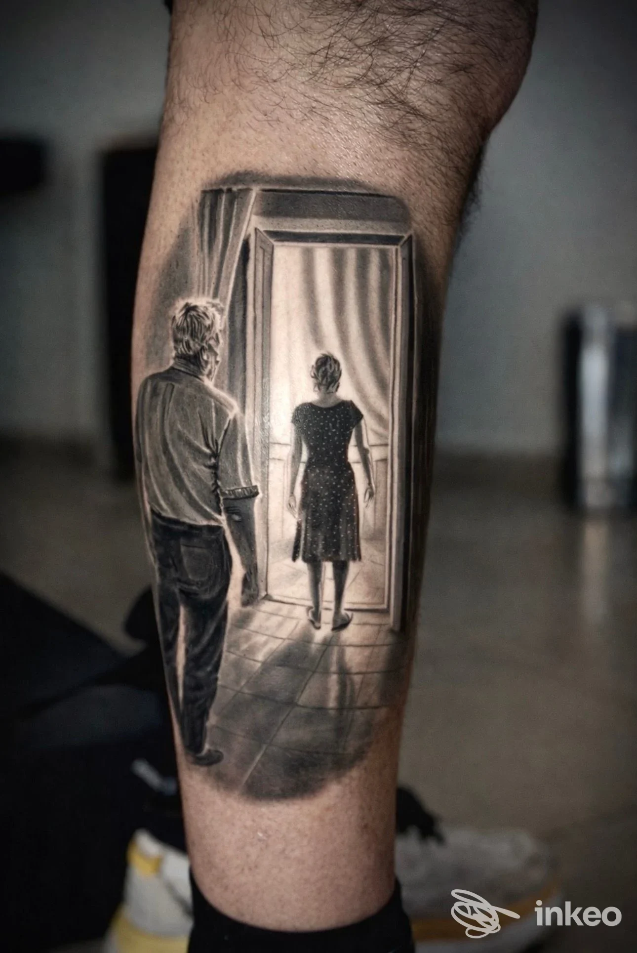 Tatuaggio realistico in bianco e nero su polpaccio che mostra due figure davanti a una porta; Lorystattoo di Lorys Calabrone, Potenza.