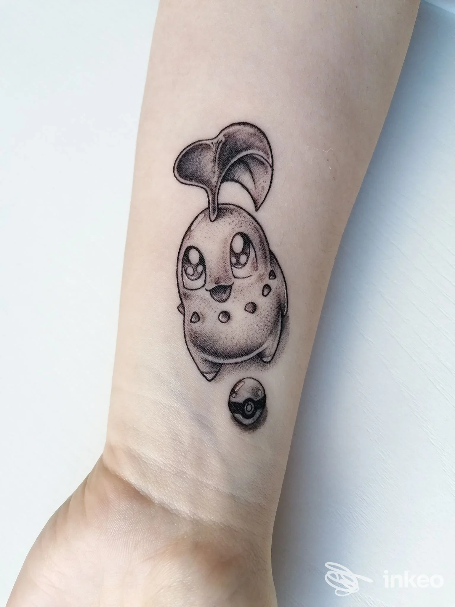 Tatuaggio in bianco e nero sull'avambraccio raffigurante un personaggio stilizzato e una piccola sfera, foto inviata da Naif Tattoo Parlour Matera.