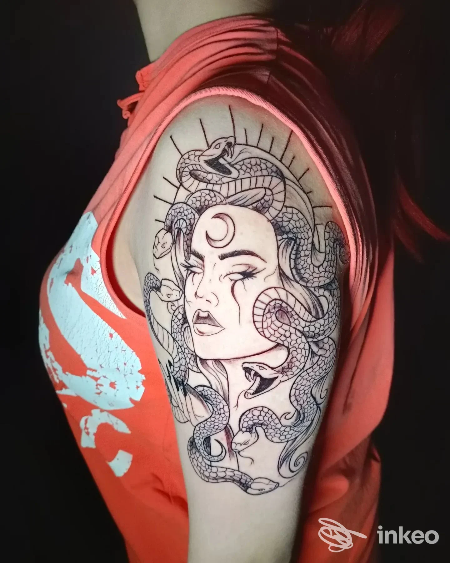 Tatuaggio in nero sul braccio superiore che mostra un volto femminile circondato da serpenti, scatto di Natalino Aghi e Inchiostro Studio Tattoo, Potenza.