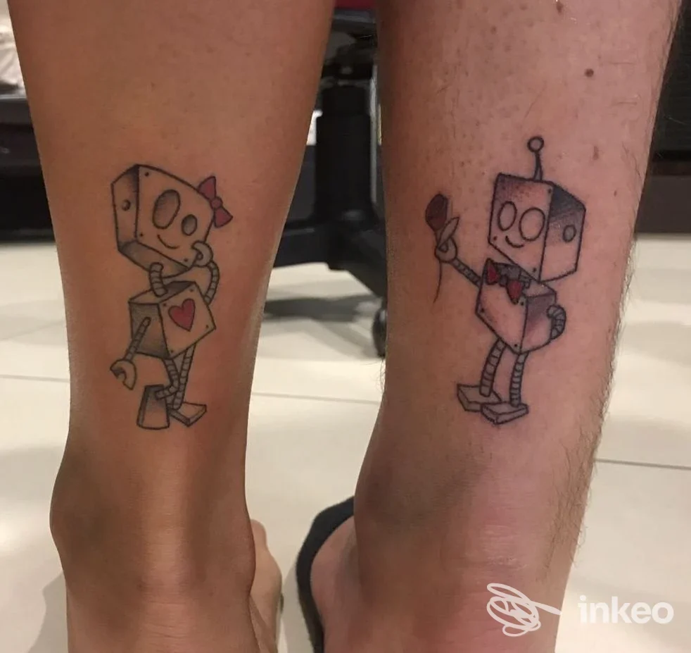 Due tatuaggi a forma di robot stilizzati sui polpacci, fotografati allo studio Play Ink Custom Tattoo a Policoro.