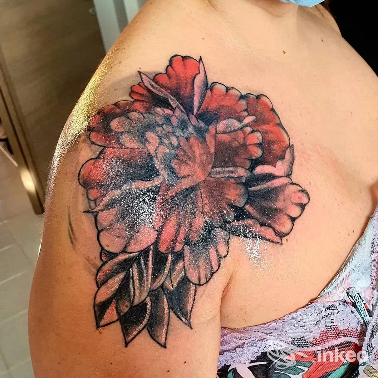 Tatuaggio floreale rosso e nero sulla spalla, foto fornita da Poison Tattoo Studio di Roberta Maisto a Potenza.