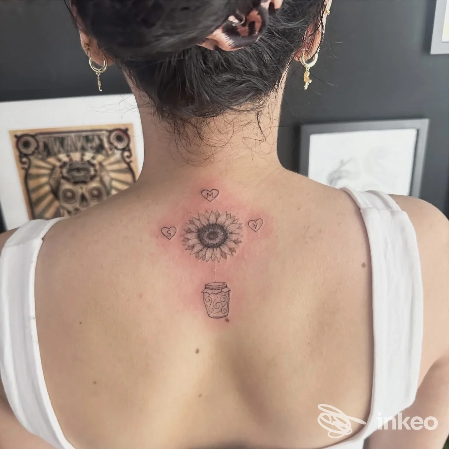 Foto della parte superiore della schiena con tatuaggio a girasole e vaso, realizzato da SKULLINK STUDIO TATTOO a Potenza.