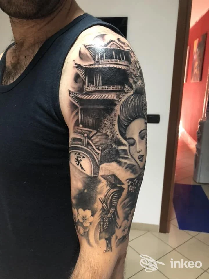 Ampio tatuaggio in bianco e nero su braccio superiore con pagoda e geisha, foto fornita da Tattoo Magic Skin a Potenza.