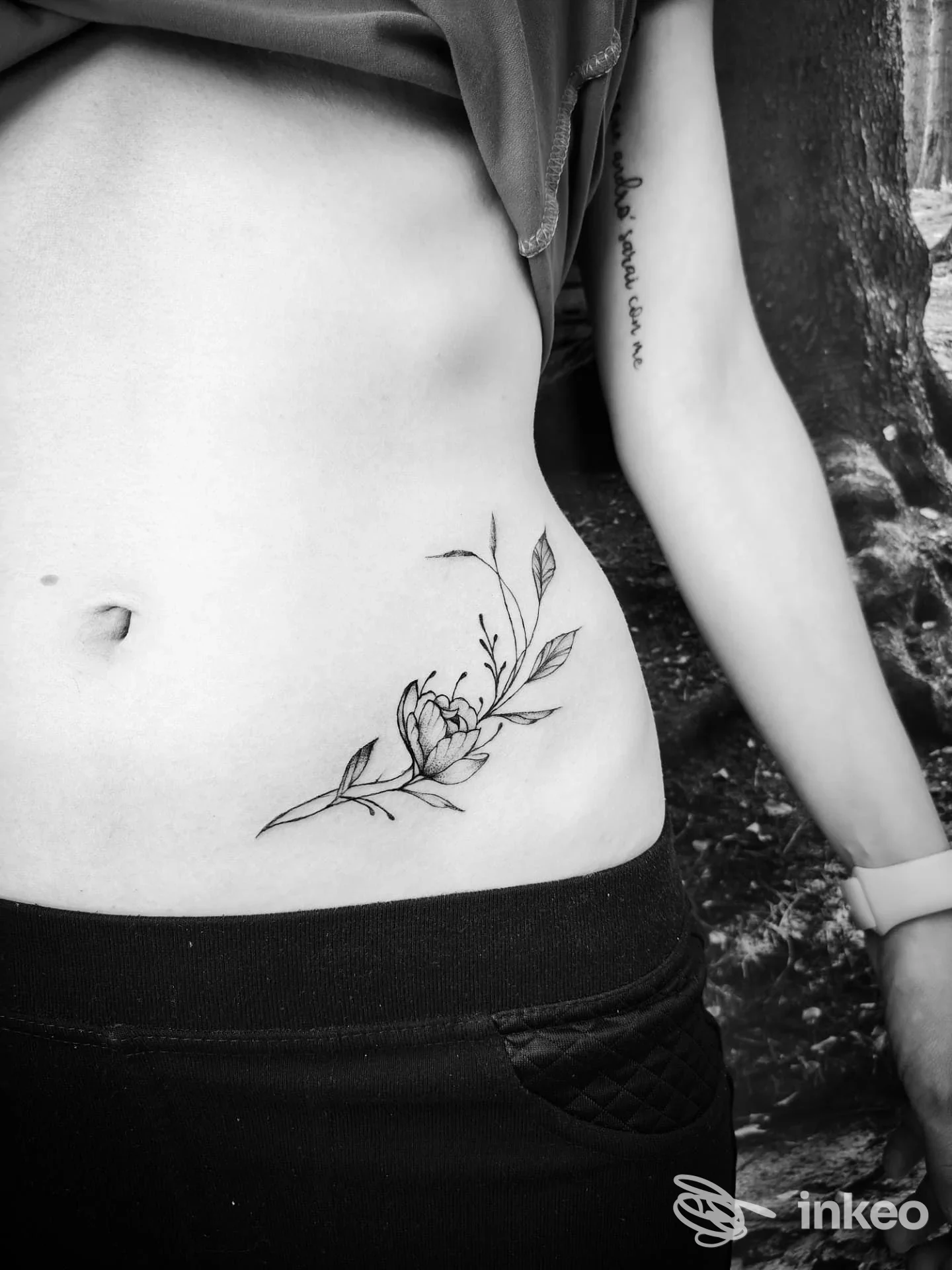 Primo piano di un tatuaggio floreale fineline sul fianco basso, foto inviata dallo studio Vazza Canio Tattoo a Scalo.