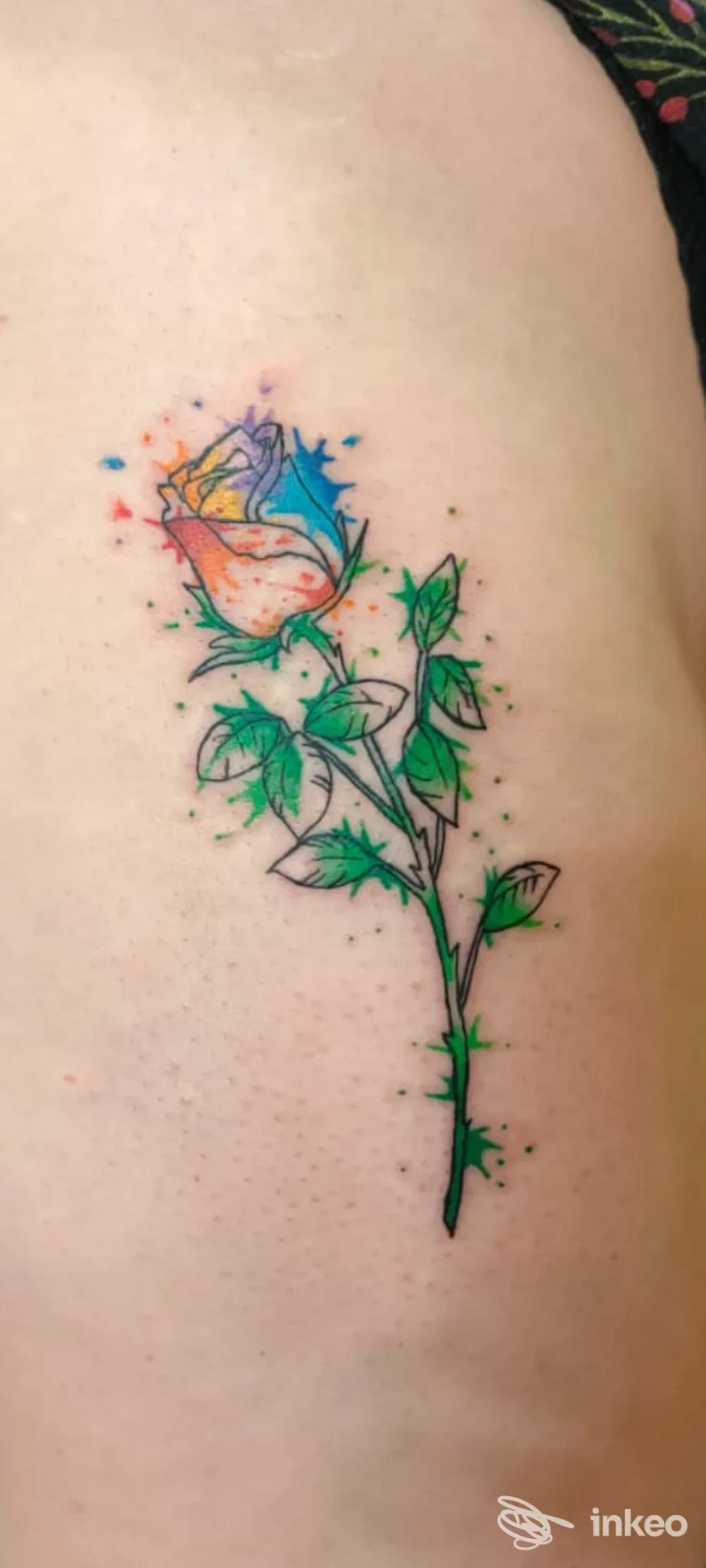 Tatuaggio di una rosa in stile acquerello sul fianco, colori vivaci e contorni neri. Medusa Tattoo & Piercing Artist, Ferrara.