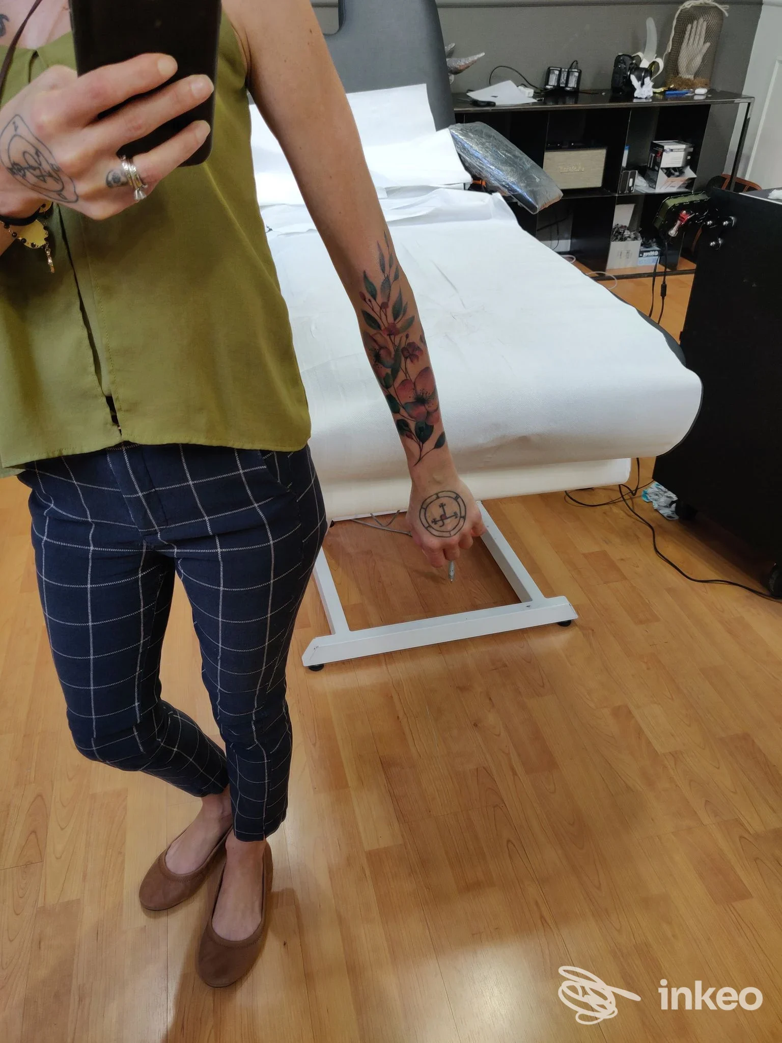 Foto in studio che mostra un tatuaggio a motivi vegetali sull'avambraccio e un piccolo tatuaggio sul dorso della mano. b/g tattoo, Livorno.