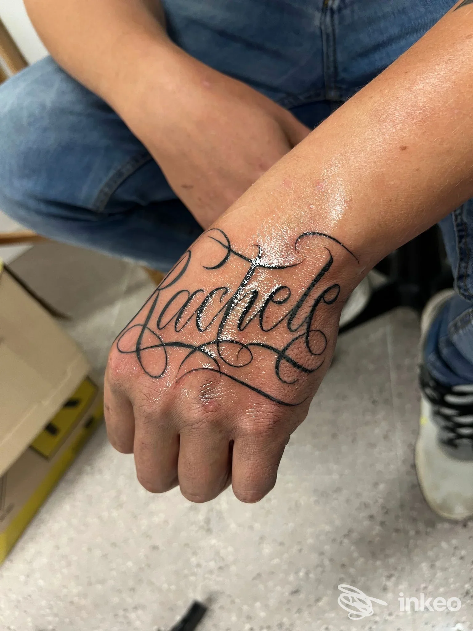 Tatuaggio in stile lettering con la scritta "Rachele" sul dorso della mano, foto fornita da 2L TATTOO & PIERCING STUDIO a Treviso.