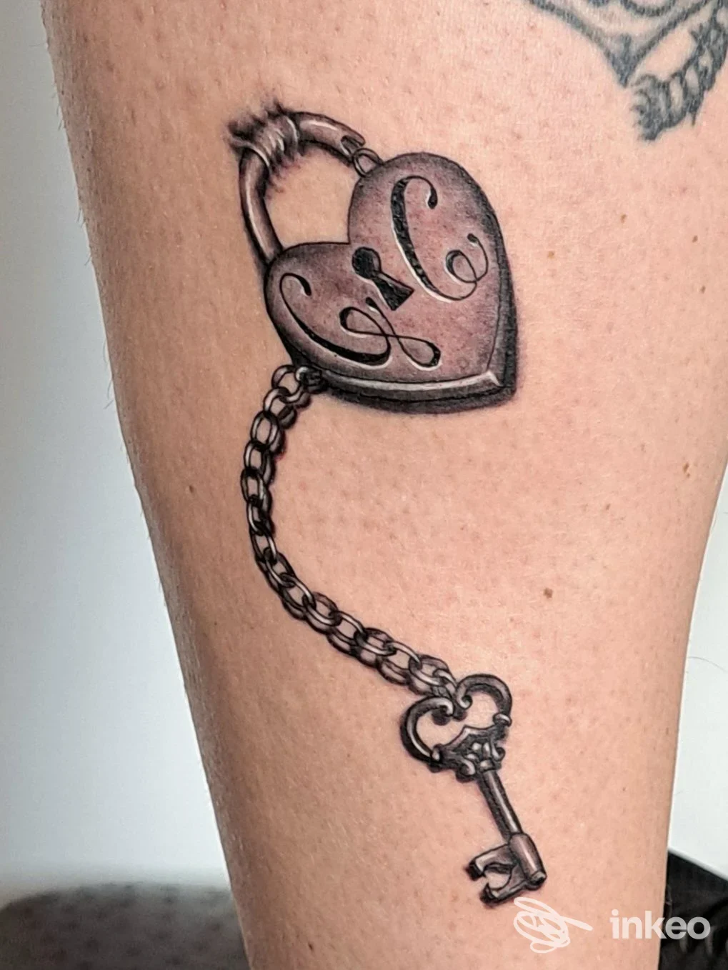 Tatuaggio di lucchetto a cuore con chiave su polpaccio, fotografia inviata da Klandestino's tattoo / piercing & tatuaggi, Pisa.