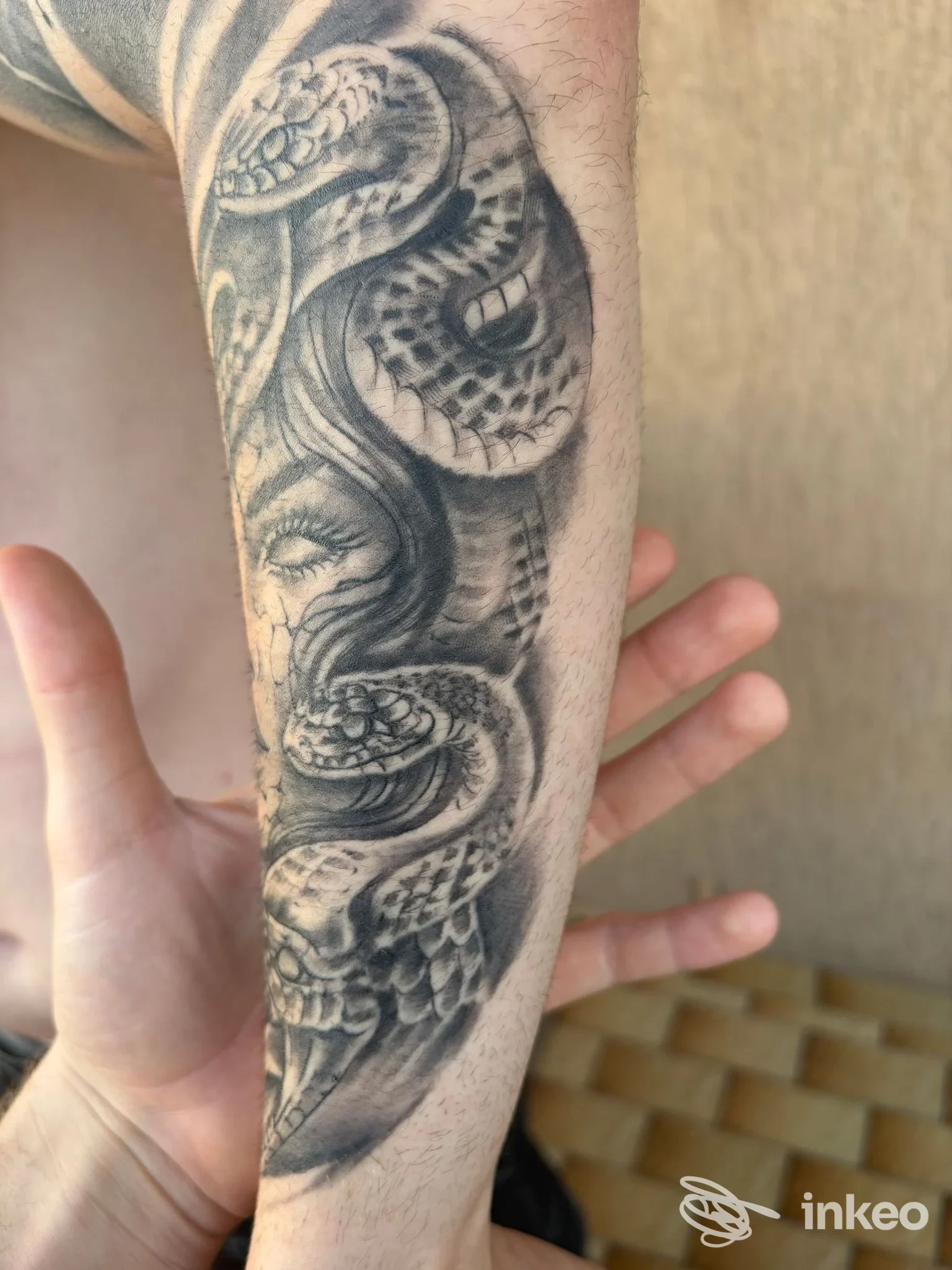 Tatuaggio black & grey su avambraccio con serpente avvolto e volto femminile, foto fornita da Dän Ink Venezia, Venezia.