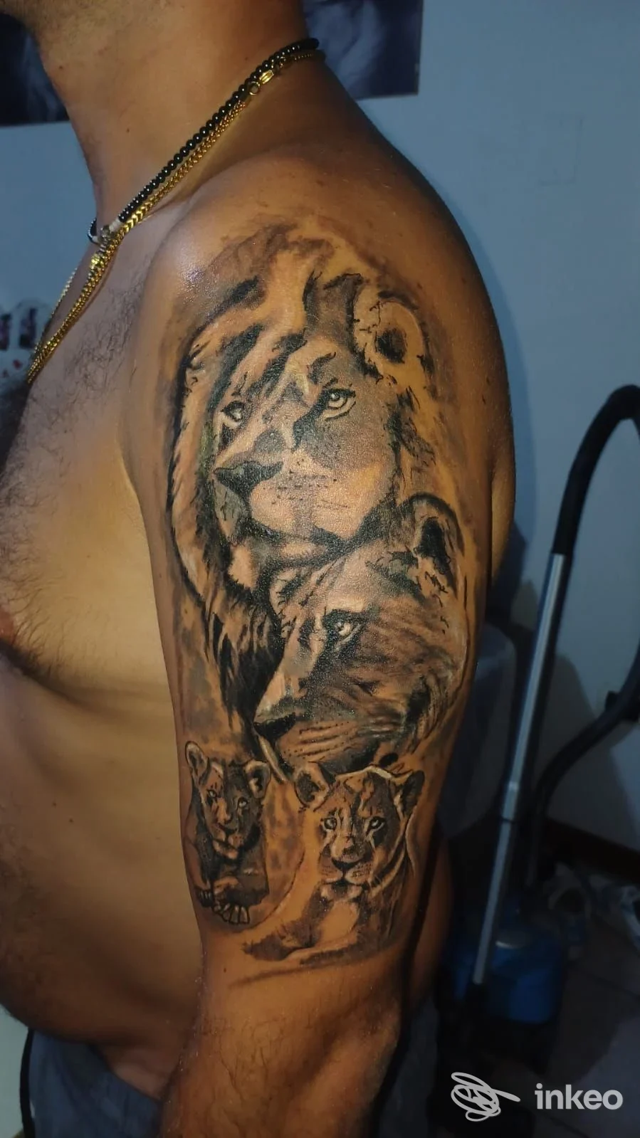 Tatuaggio realistico in bianco e nero con più leoni sull'omero, realizzato da Dän Ink a Venezia, mostrato su un cliente in primo piano.