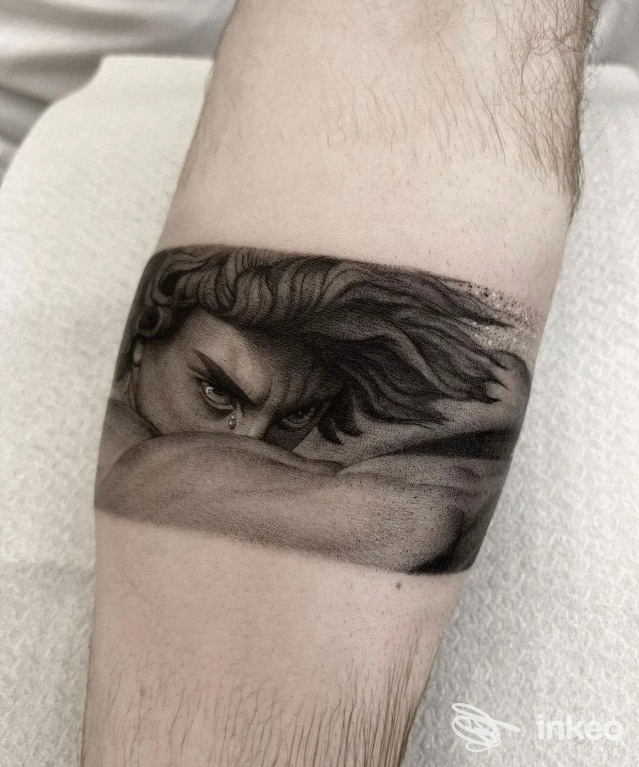 Tatuaggio in bianco e nero raffigurante un volto stilizzato sull'avambraccio, Loser Studio, Firenze.