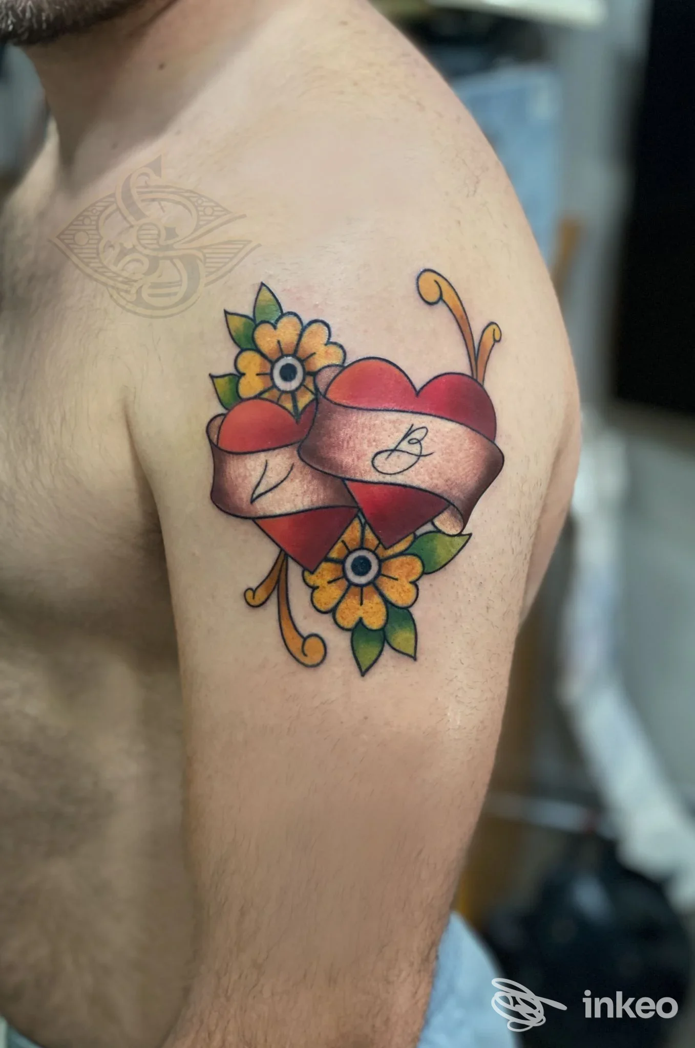 Tatuaggio colorato a forma di cuore con fiori sul braccio superiore, realizzato da Gilas Tattoo a Napoli.