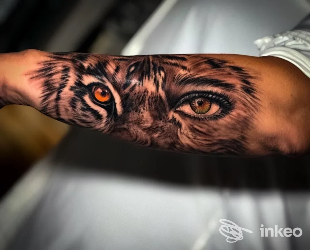 Tatuaggio realistico di occhi di tigre sull'avambraccio, dettagli e colori nitidi eseguiti da Gilas Tattoo, Napoli.