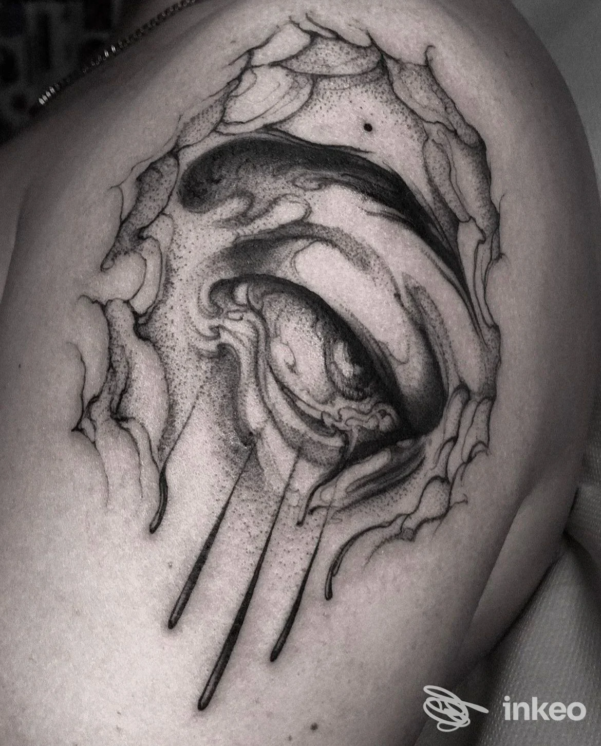 Tatuaggio black & grey a forma di occhio con effetto pelle lacerata sul deltoide, foto fornita da Sorry Mom Tattoo, Bologna.