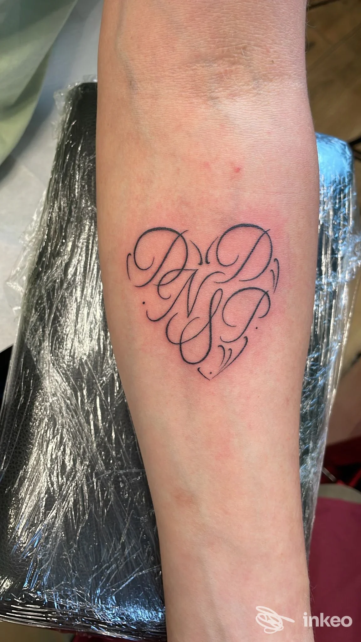 Tatuaggio calligrafico a forma di cuore sull'avambraccio, foto fornita da Midori Ink, Scandicci.