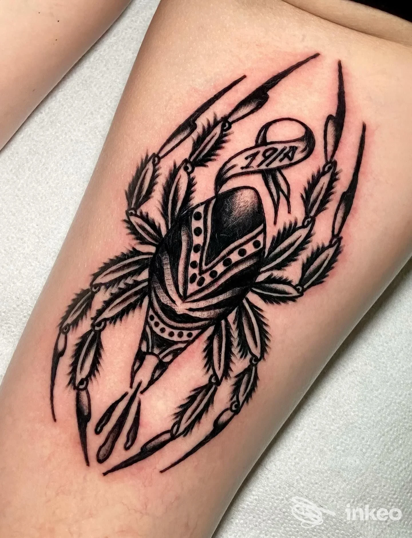 Tatuaggio nero su avambraccio con motivo a foglie e nastro, scattato da Mea Culpa Tattoo Studio, Bologna.