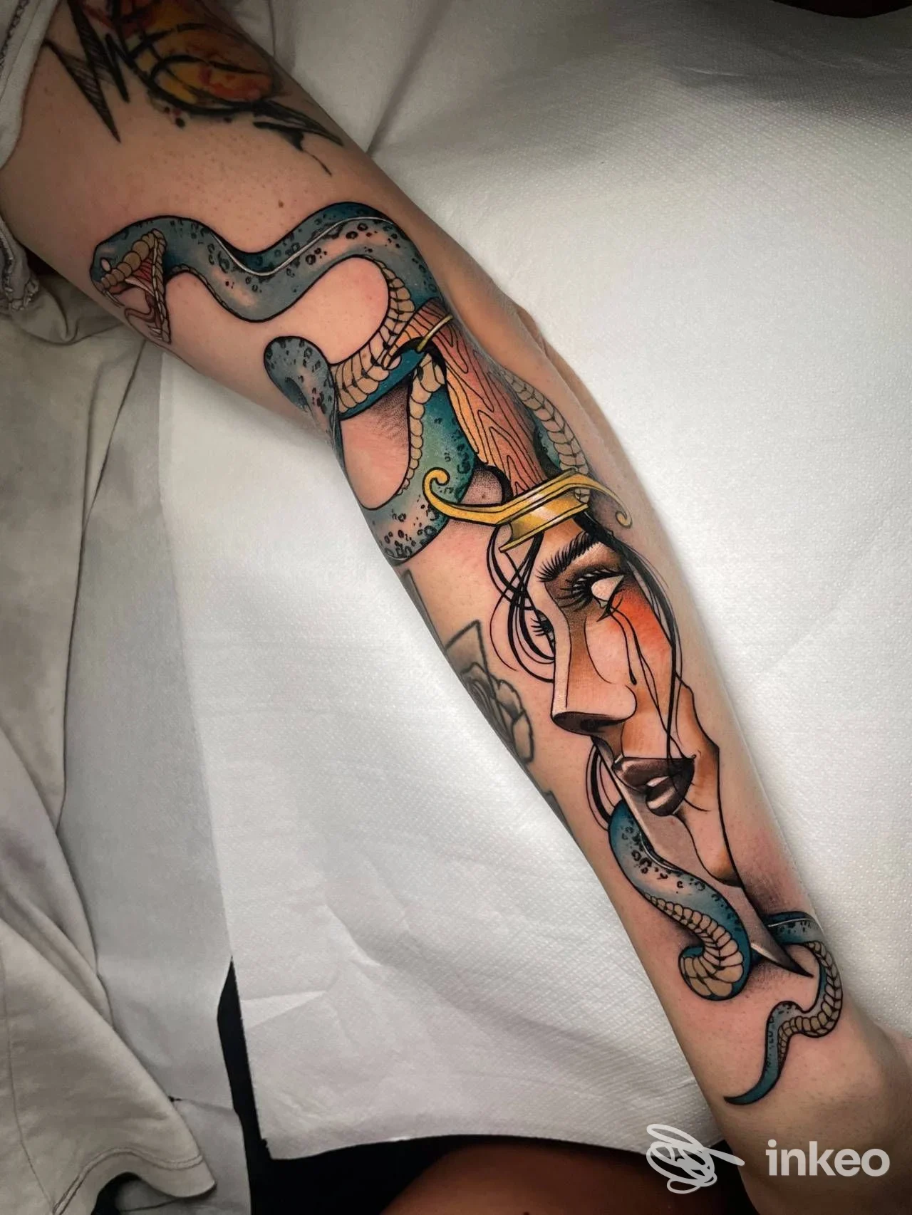 Tatuaggio su avambraccio con figura femminile stilizzata e serpente, Black Virgo Tattoo Studio, Bologna.