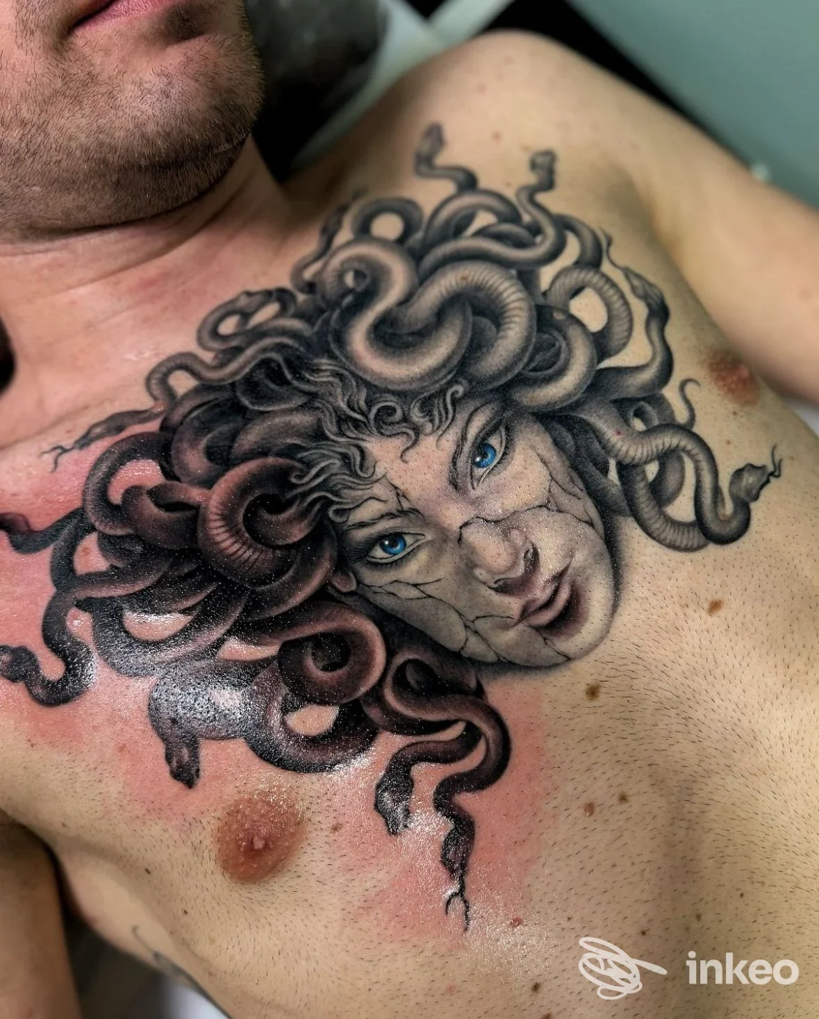 Grande tatuaggio Medusa realistico sul petto di un uomo, dettagli in nero con occhi blu. Red Rose Tattoo, Scandicci.
