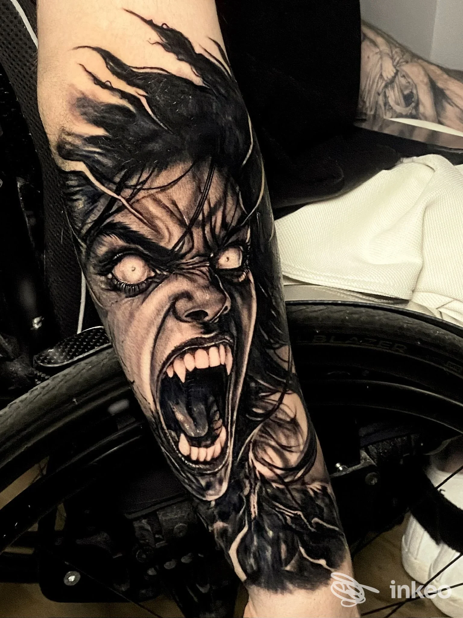 Tattoo realistico su avambraccio raffigurante una faccia urlante con dettagli scuri, eseguito su pelle reale, nessun testo o watermark visibile peric.
