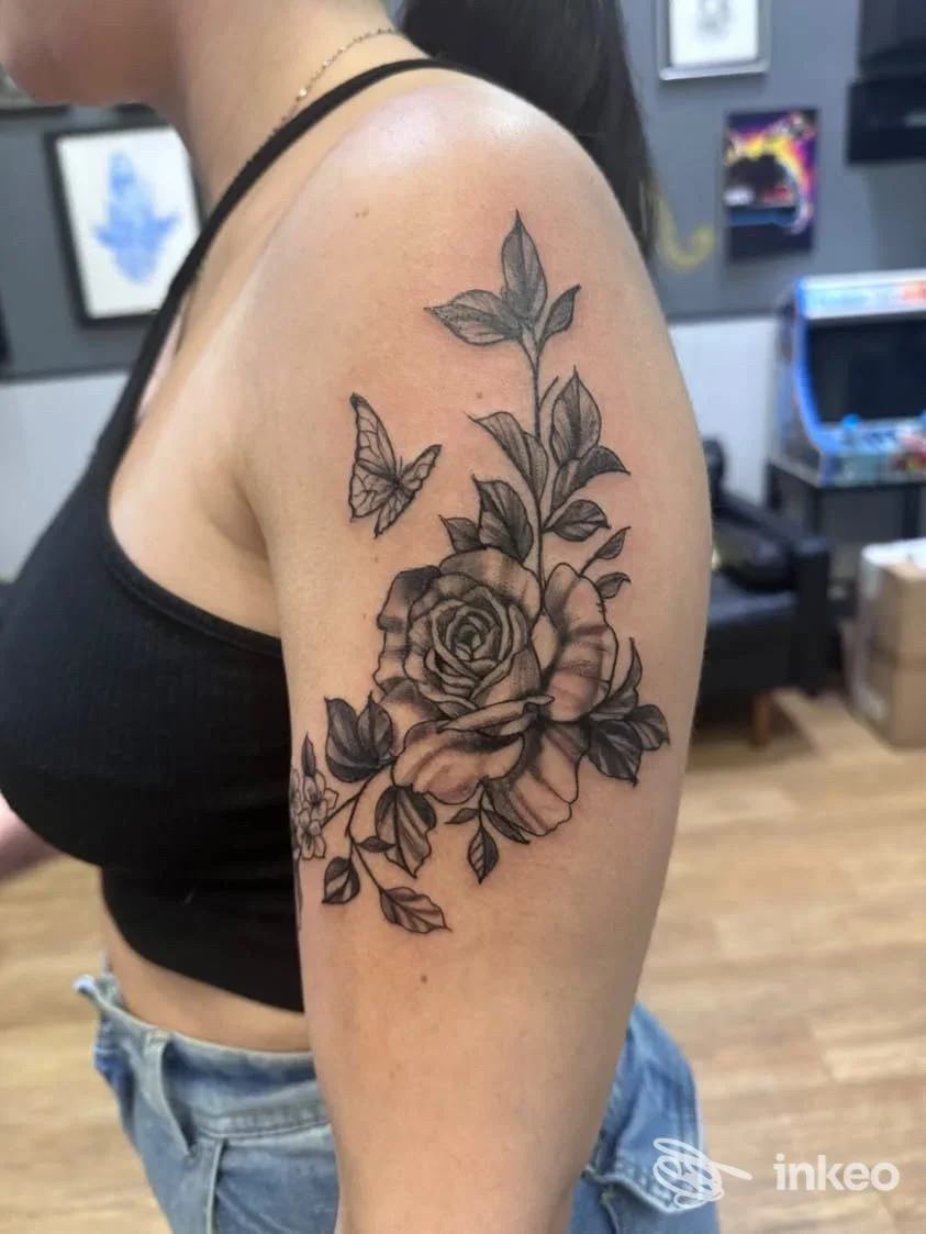 Tatuaggio floreale in nero sul braccio superiore di una donna, foto realizzata da Blink Tattoo Studio a Sorrento.