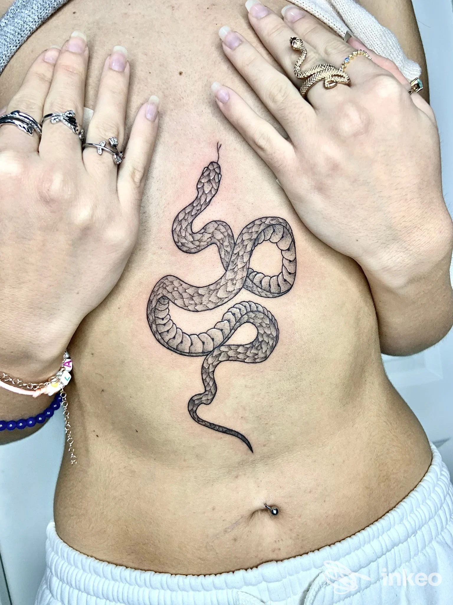 Tatuaggio di un serpente nero sull'addome, Opera | Art & Tattoo Crew, Portici.