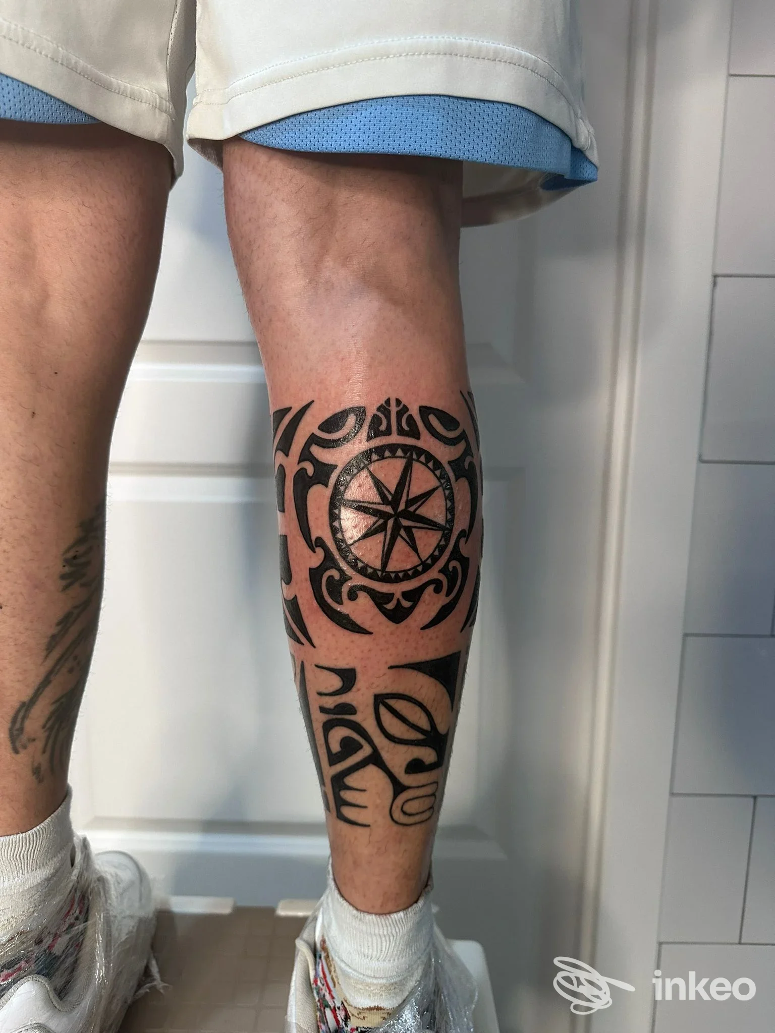 Tatuaggio tribale nero sul polpaccio destro di un uomo, scatto in interno fornito da Opera | Art & Tattoo Crew a Portici.