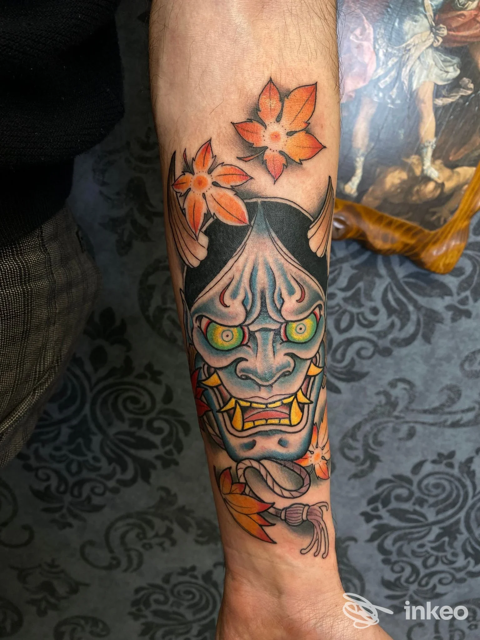 Tatuaggio Hannya colorato sull'avambraccio con fiori, realizzato da Cherry Tattoo & piercing, Imola.
