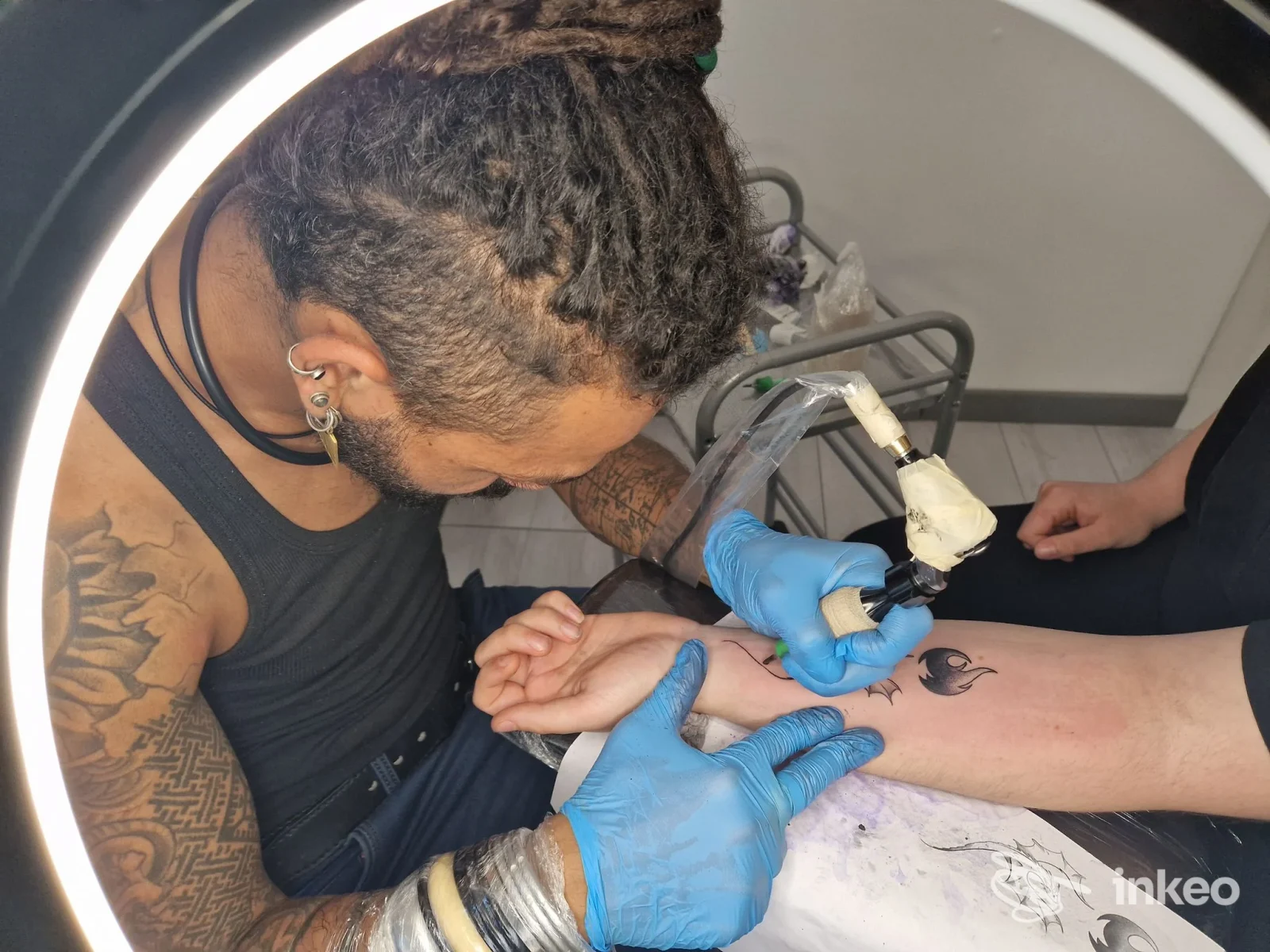 Artista al lavoro su un tatuaggio all'avambraccio presso Ink Shake Tattoo Studio, Ravenna; primo piano della sessione in corso.