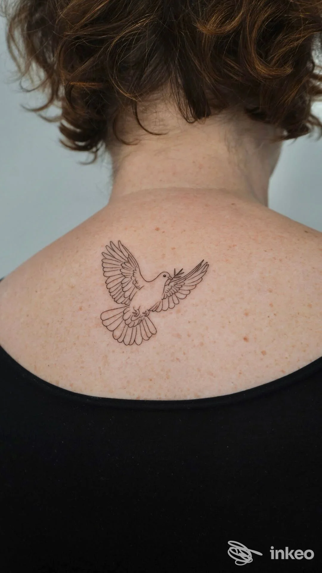 Tatuaggio a linee di un uccello in volo al centro della parte superiore della schiena. META tattoo lab, Bologna.