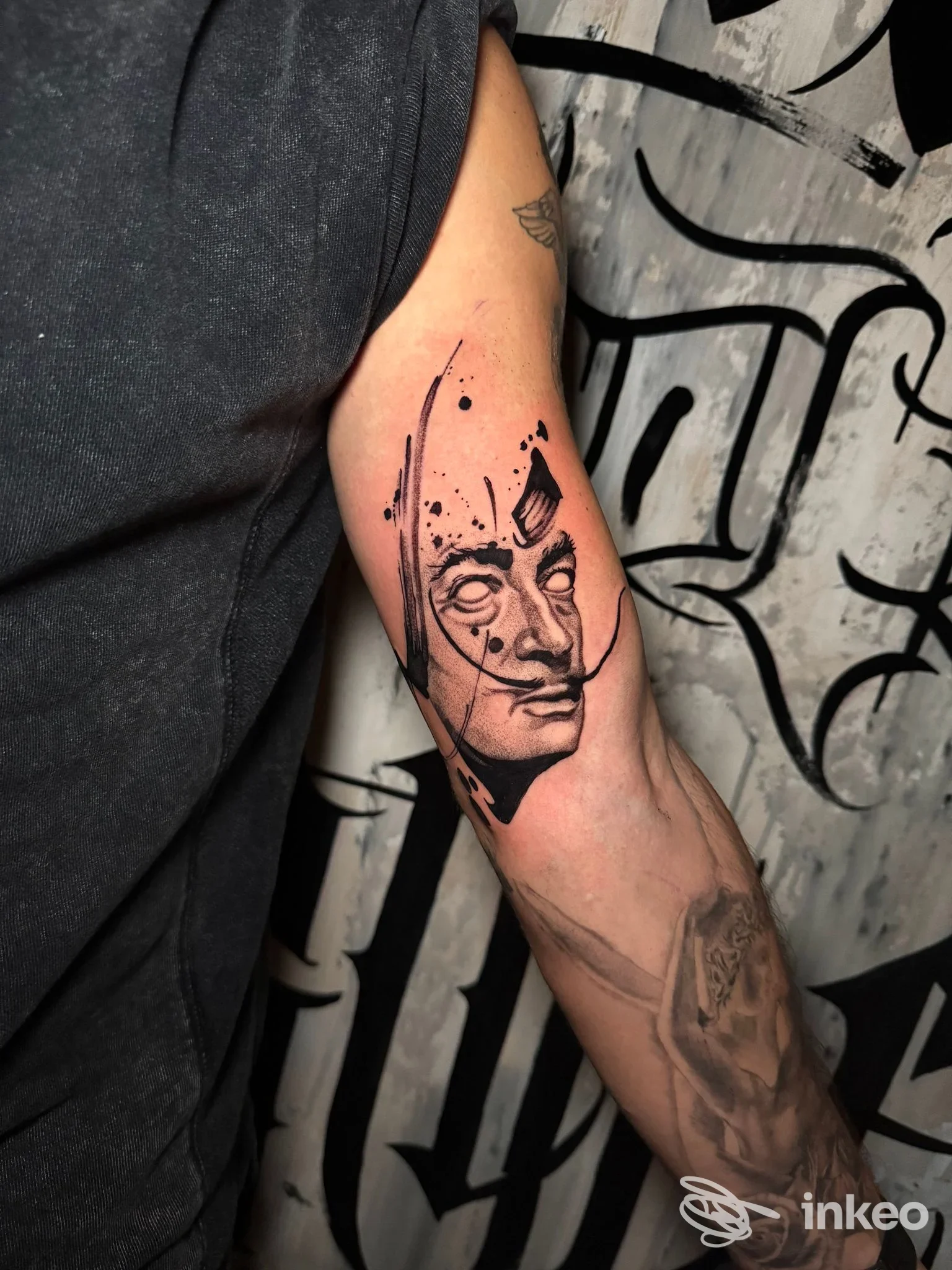 Tatuaggio in nero di un volto stilizzato sull'avambraccio, foto per Free Your Style Tattoo Studio, Torre del Greco.