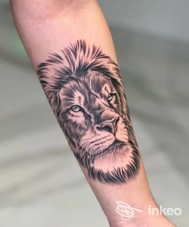 Tatuaggio realistico in bianco e nero di una testa di leone sull'avambraccio, DelaRoche Tattoo, Lugo.