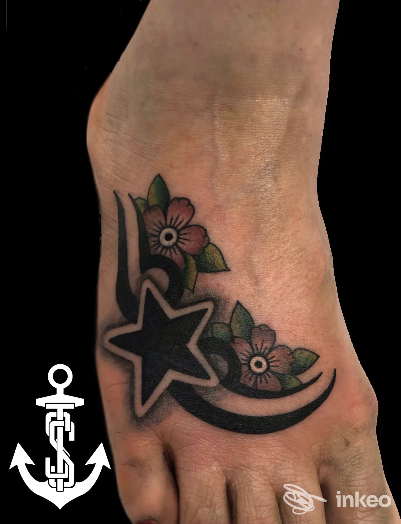 Tattoo sul piede con stella nera e fiori rosa, realizzato da Street Style Tattoo.