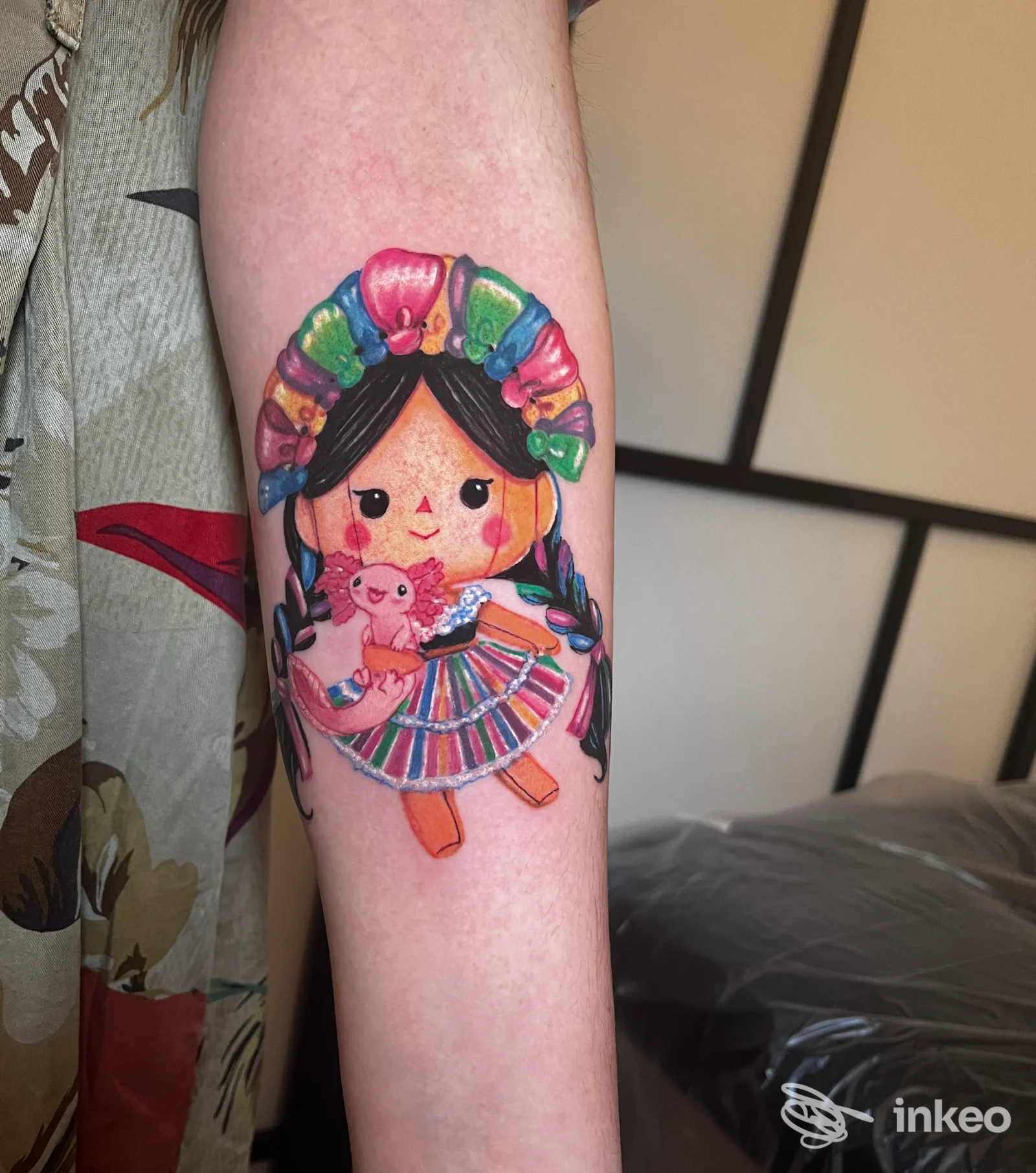 Tatuaggio colorato a soggetto bambola sul avambraccio, fotografia inviata da Skullfield Professional Tattoo Lab a Faenza.