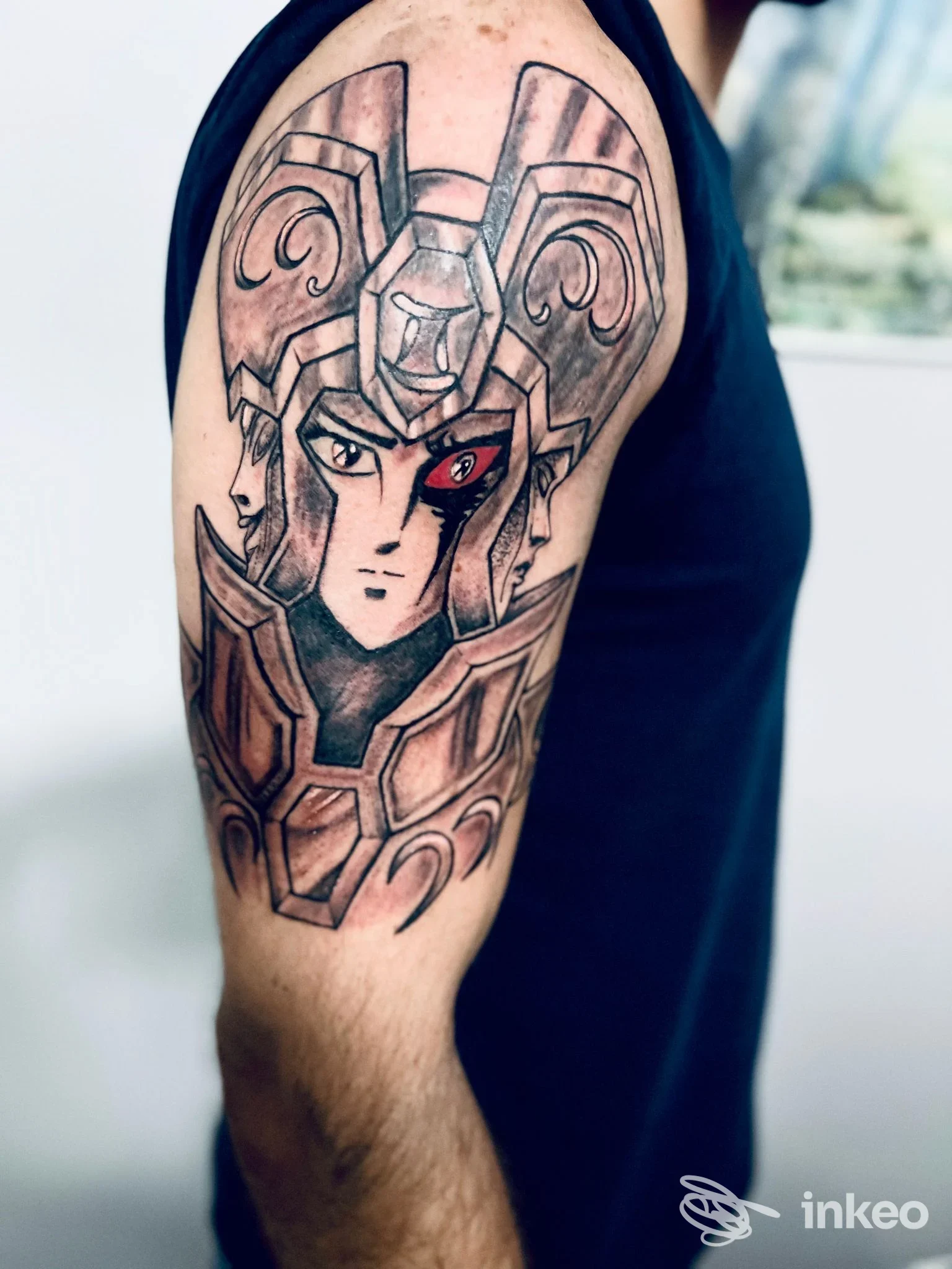 Tatuaggio su parte alta del braccio con volto ed elmo stilizzato, foto inviata da Ravenna Ink Tattoo & Piercing, Ravenna.