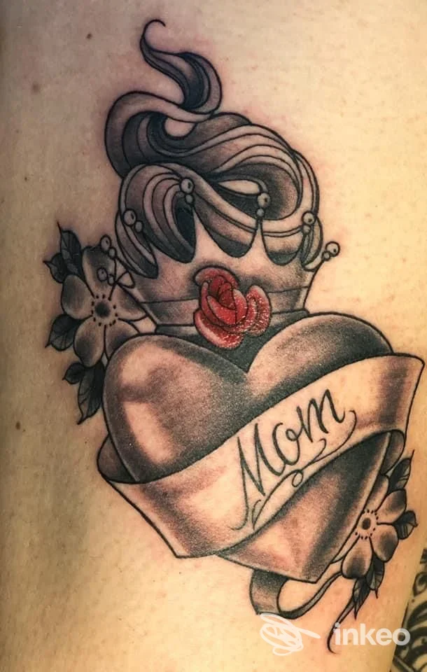 Tatuaggio a cuore con striscione 'Mom' e decorazioni floreali, foto inviata da Best Times Tattoo a Copparo.