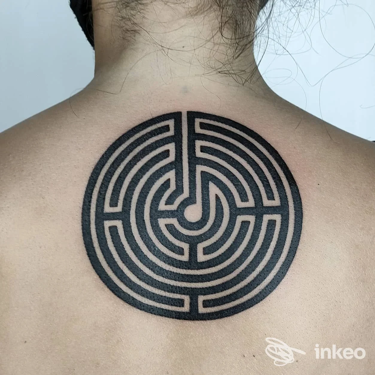 Grande tatuaggio geometrico a forma di labirinto sul dorso superiore, realizzato da Empathik Tattoo & Piercing Studio a Medicina.