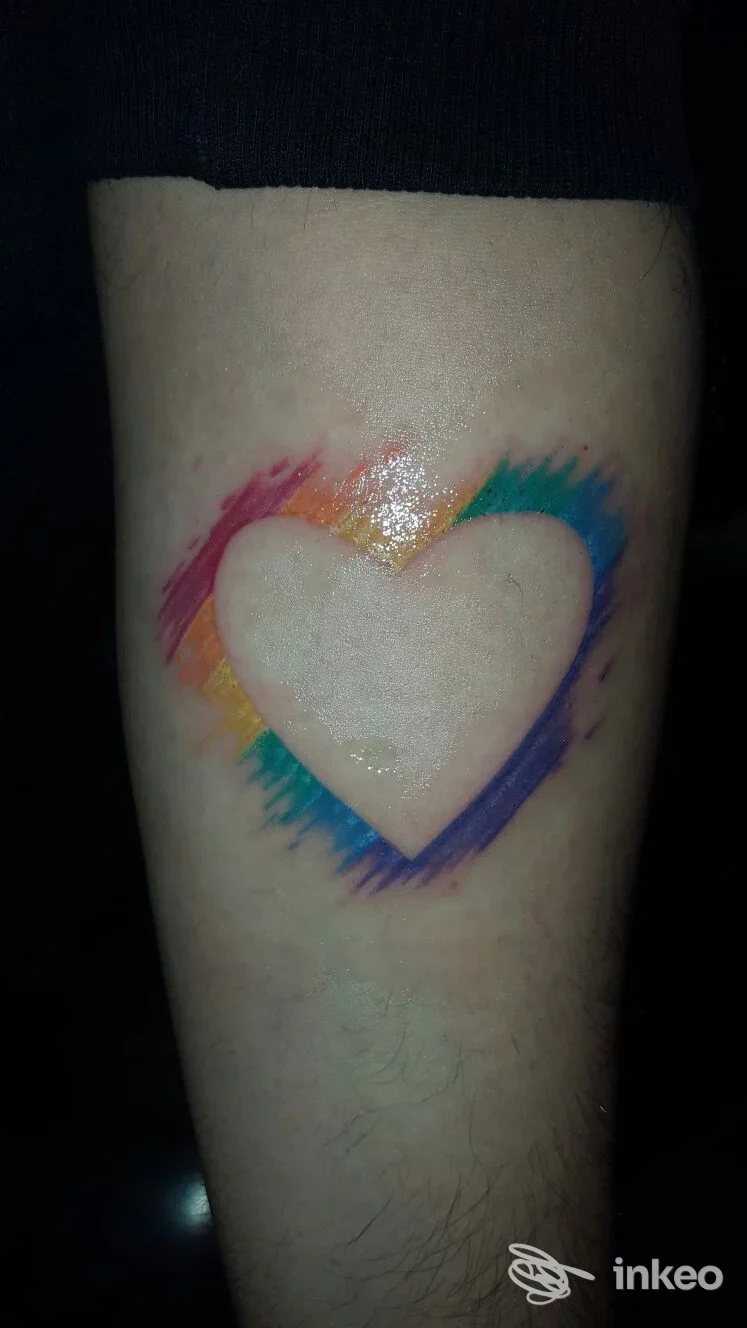 Tatuaggio a cuore negativo con pennellate arcobaleno su avambraccio. Foto inviata da Seretattoo a Campogalliano.