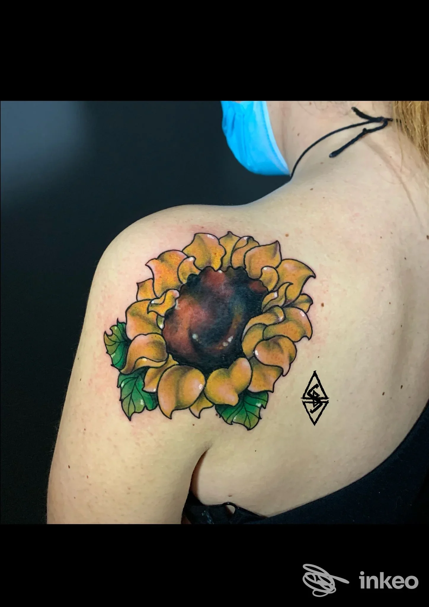 Tatuaggio colorato di girasole sulla spalla sinistra, fotografia del lavoro eseguito da Ars Goetia Tattoo Studio, Ferrara.