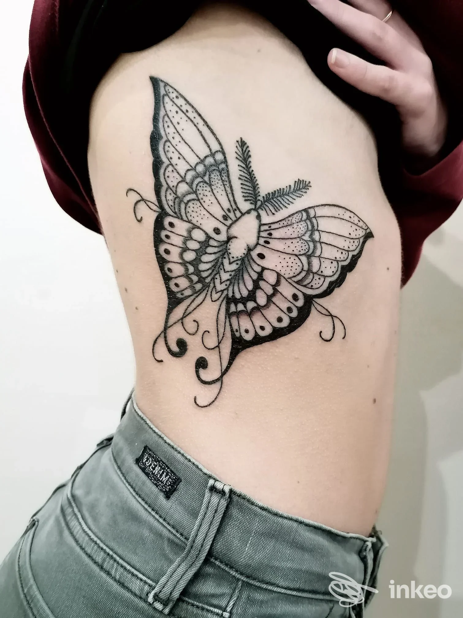 Tatuaggio a farfalla in bianco e nero sul fianco, fotografia inviata da Immagine Tattoo, Forlì.