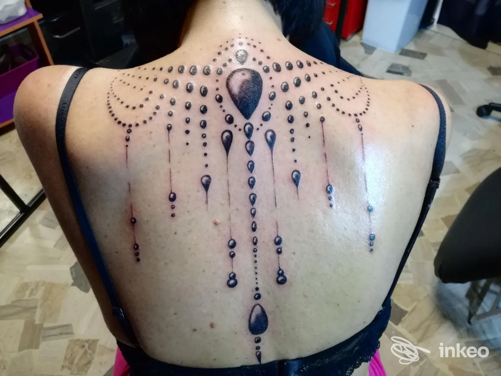 Grande tatuaggio ornamentale a perline e gocce sulla schiena di una cliente, realizzato da Immagine Tattoo a Forlì.
