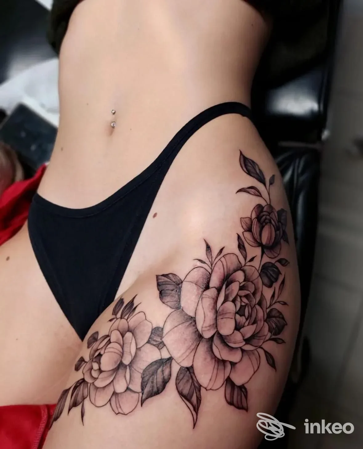 Ampio tatuaggio floreale in nero e grigio sul fianco e alta coscia, foto condivisa da No Class Tattoo Shop a Minerbio.