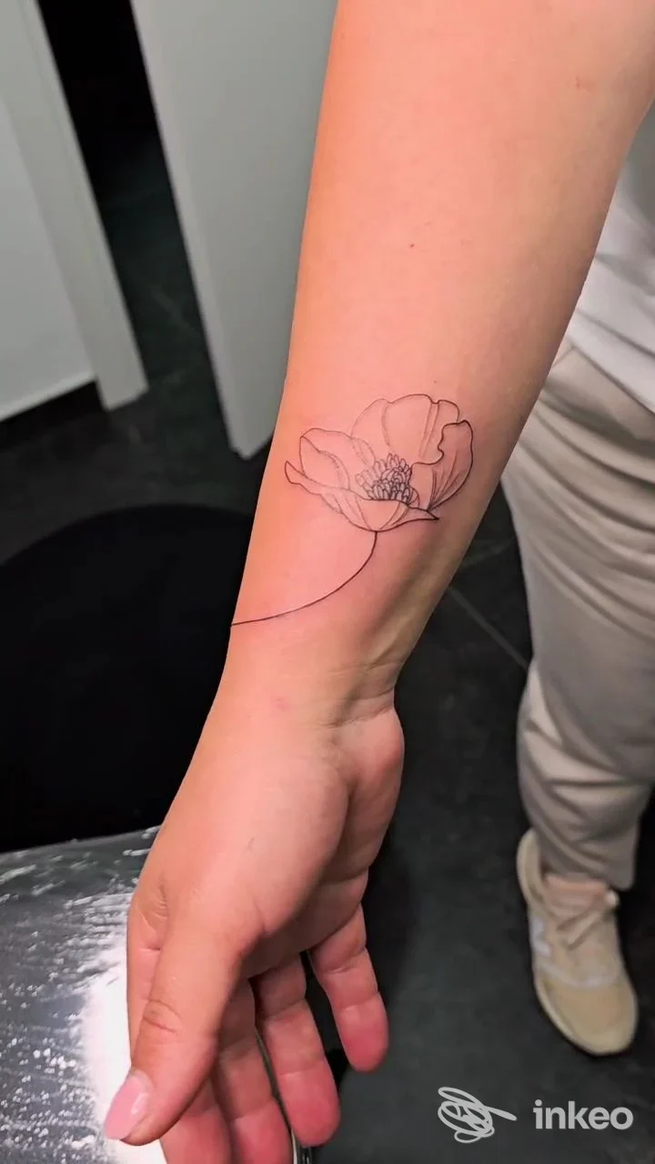 Tatuaggio a linee sottili di un fiore sull'avambraccio interno, realizzato da Soul Ink Tattoo Studio a Pollena Trocchia.