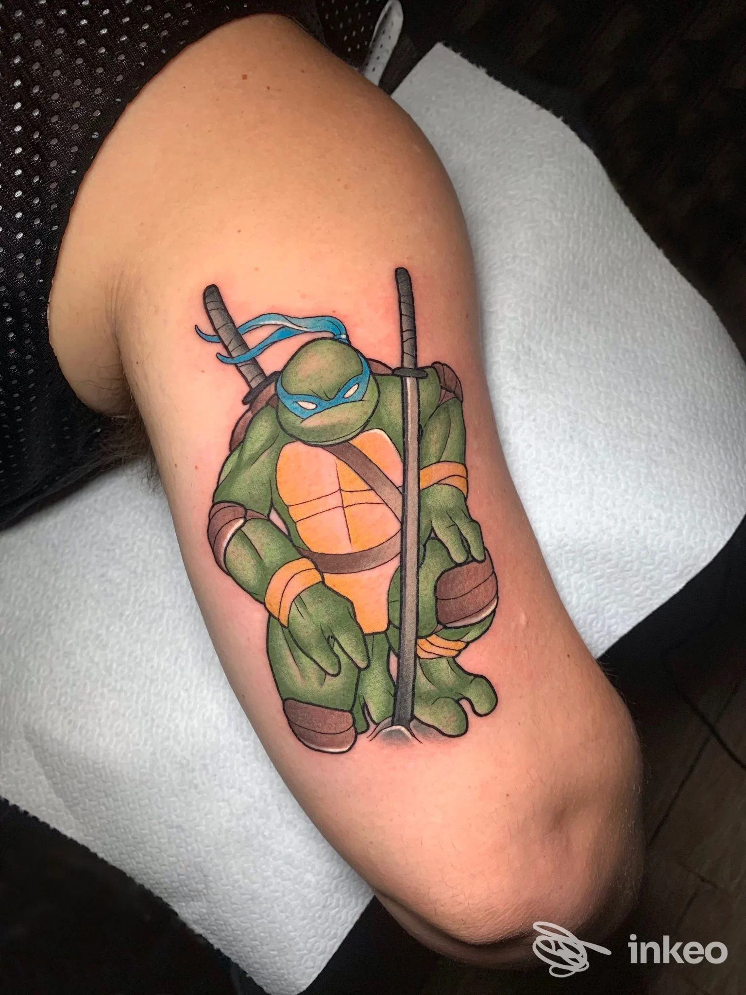 Tatuaggio a colori di una tartaruga ninja sul bicipite, realizzato da Street Dream Tattoo a Bologna, linea netta e riempimenti uniformi.