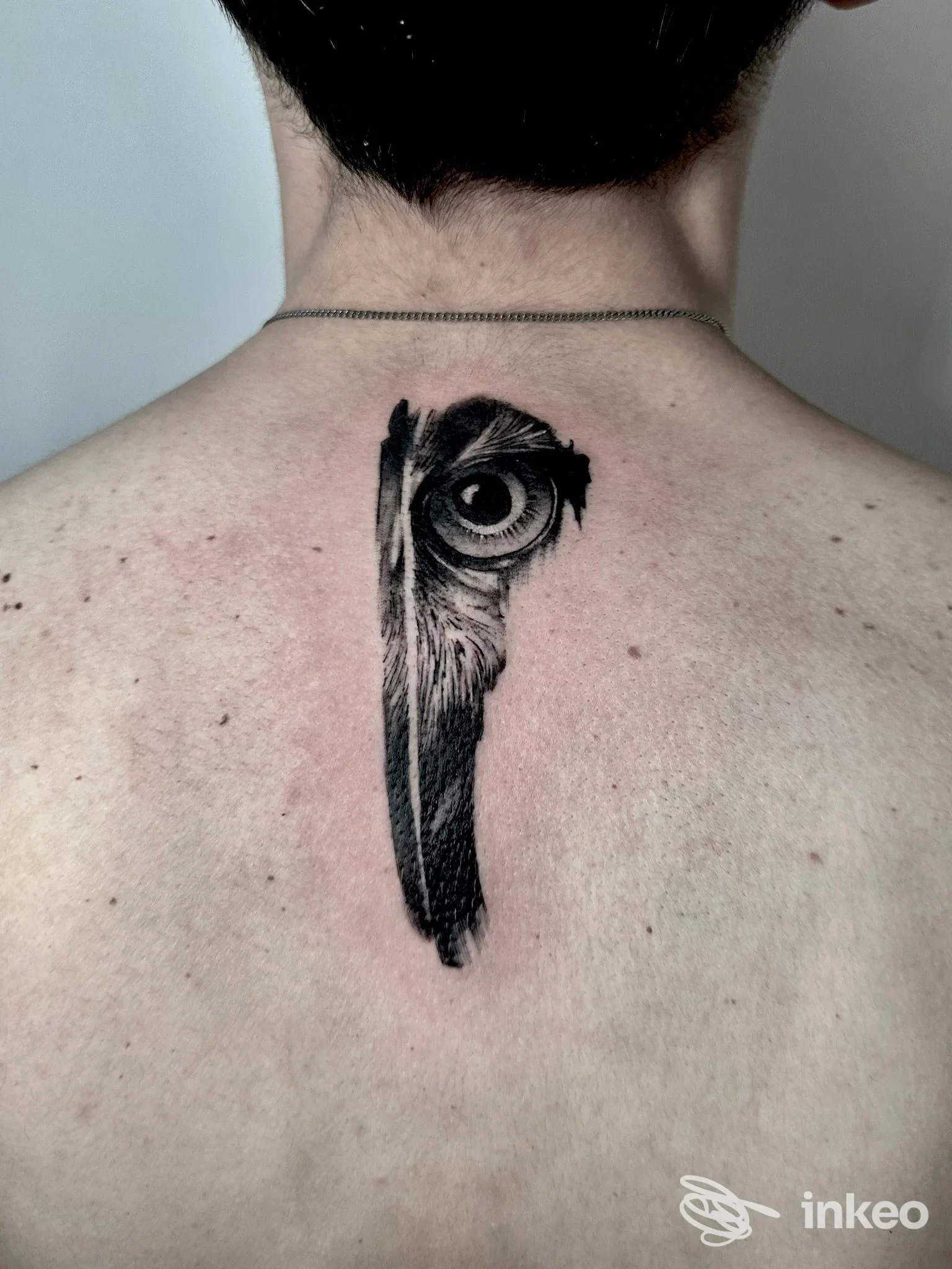 Tatuaggio realistico a inchiostro nero con un occhio, posizionato sotto la nuca. Indigo Tattoo, Sant'Agata Bolognese.
