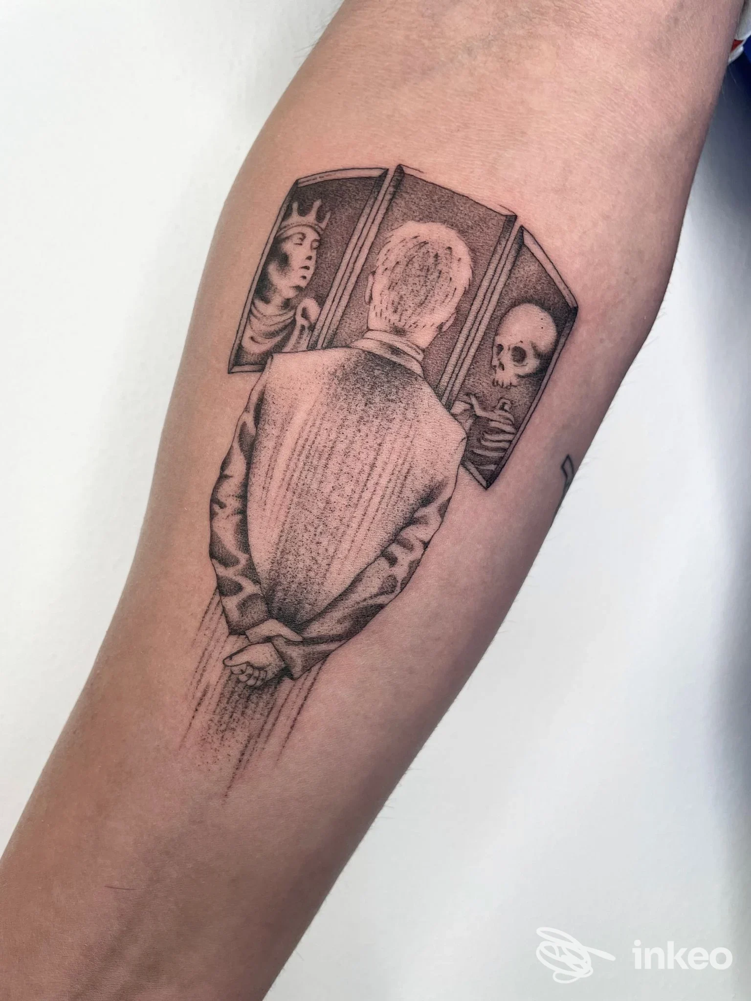 Tatuaggio in bianco e nero su avambraccio con figura vista di spalle e tre riquadri illustrati — Indelebile Tattoo Studio, Ravenna.