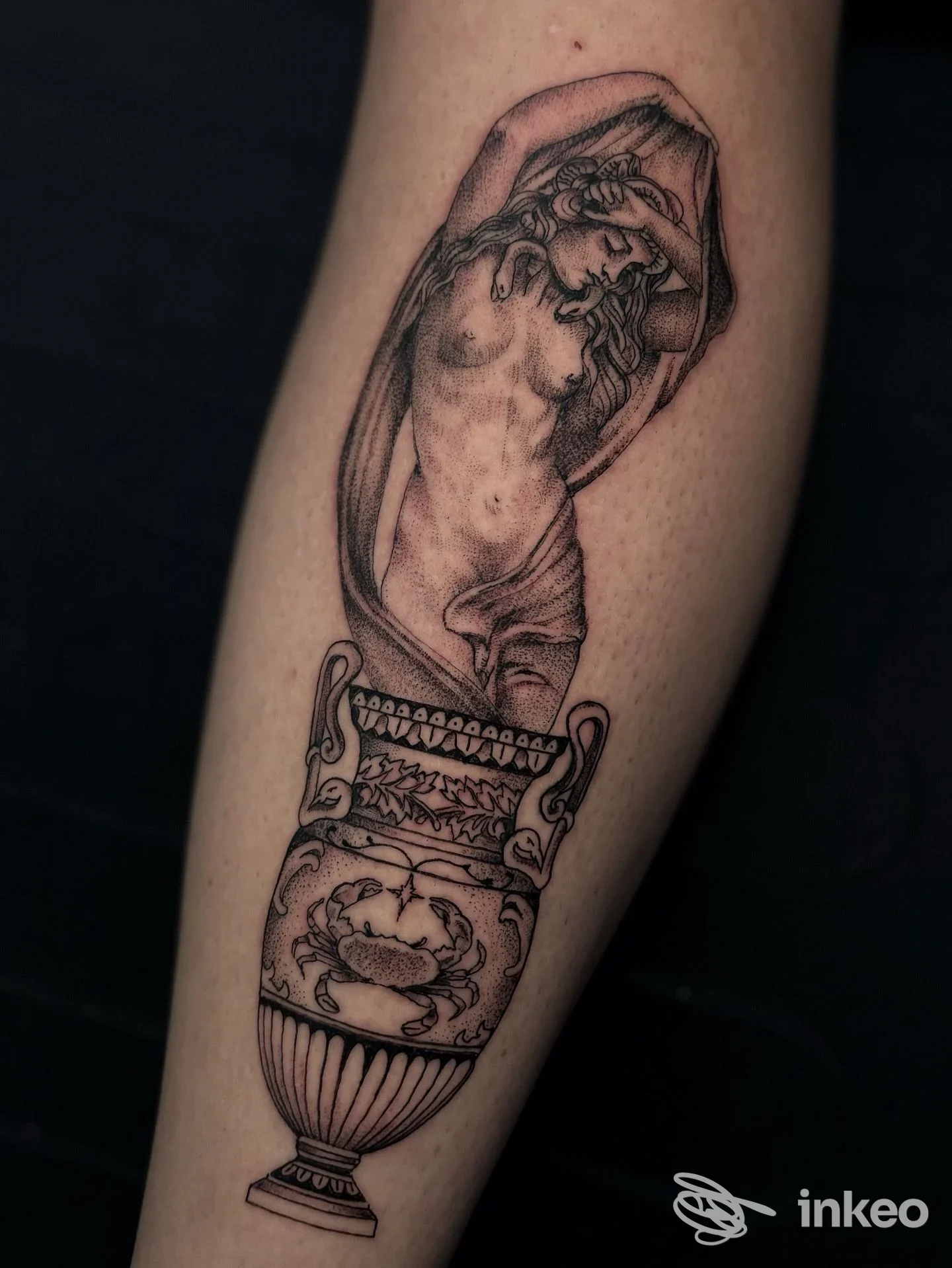 Tatuaggio blackwork su avambraccio raffigurante un vaso decorato da una figura umana emergente, foto fornita da Dot Tattoo Studio, Castellammare di Stabia.