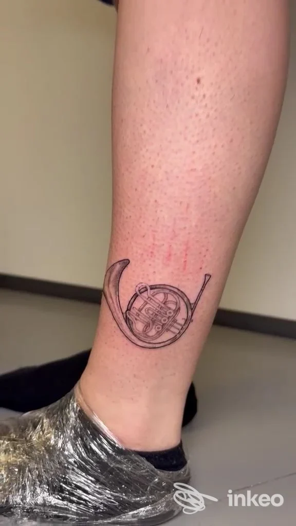 Tatuaggio di un corno francese sul polpaccio, foto da Trama Studio Walk in Tattoo a Bologna.
